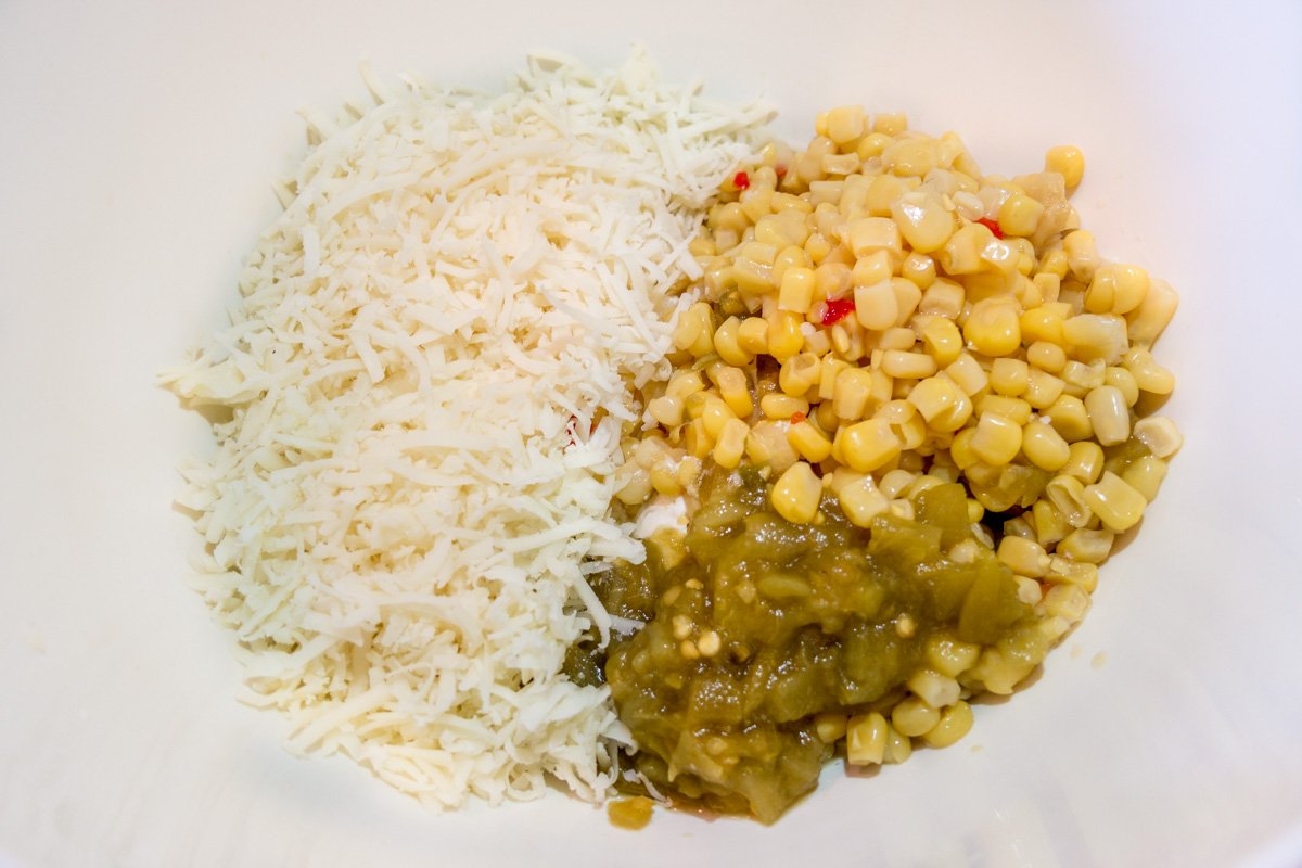 Mixing in the ingredients for hot cheesy corn dip