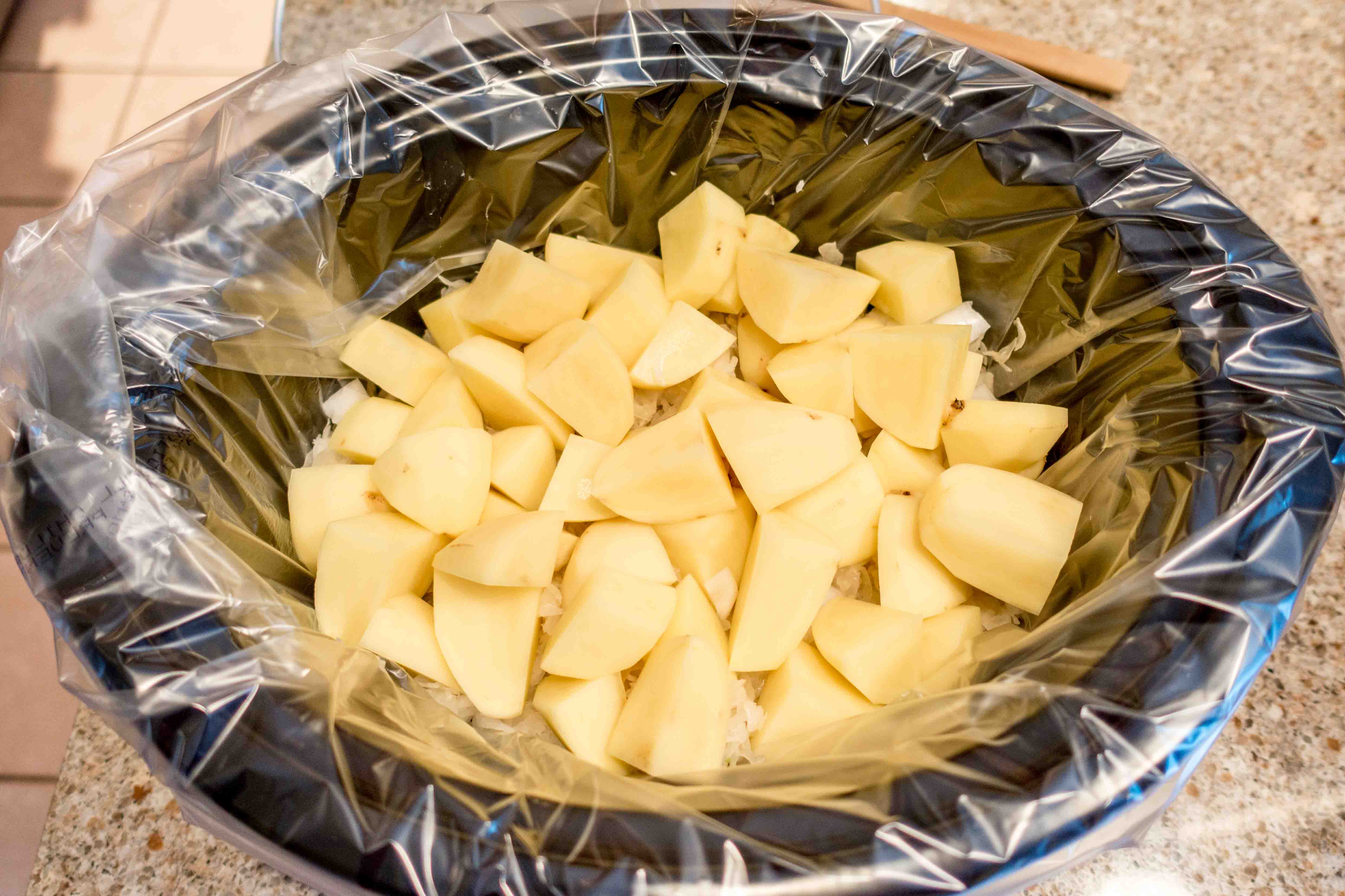 Potatoes, onion, sauerkraut, and beer in a slower cooker