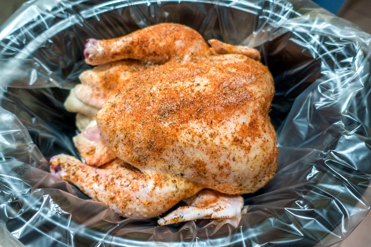 Place the seasoned whole chicken in the slow cooker and make sure the top fits.