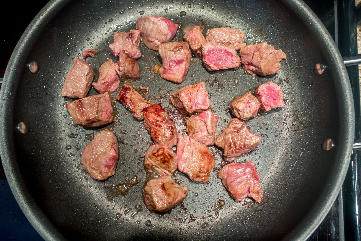 Seared beef cubes in pan 