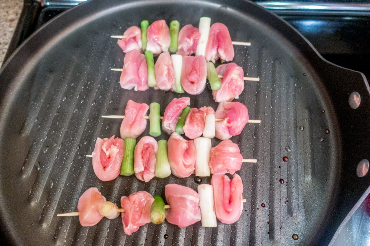 Chicken yakitori skewers grilling on grill pan