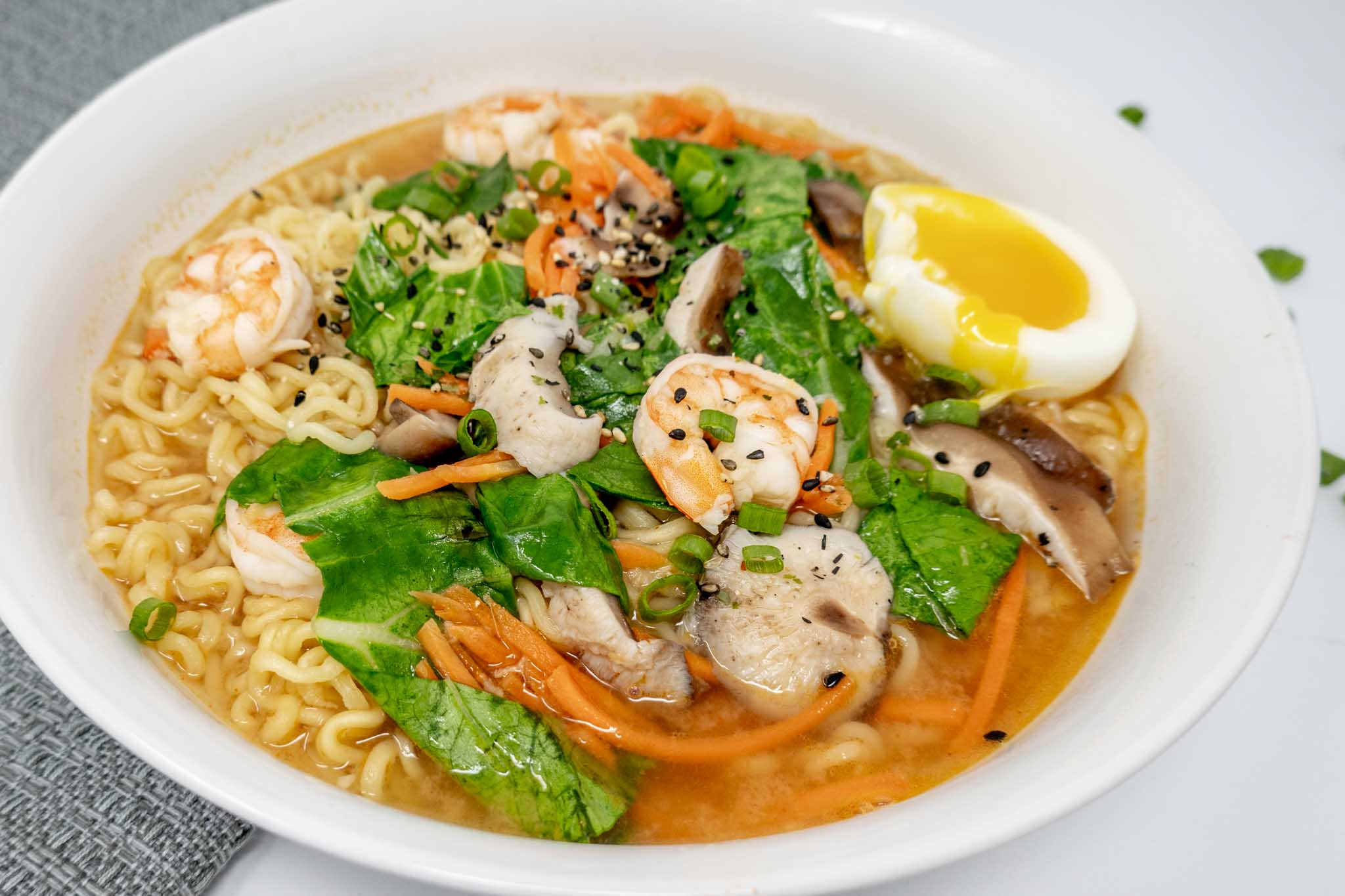 Bowl of spicy ramen with shrimp, noodles, broth, and egg