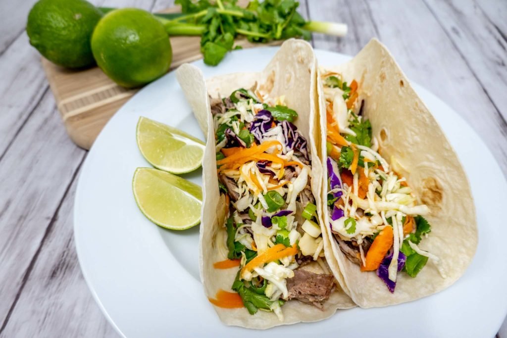 Tacos and slices of lime on a plate