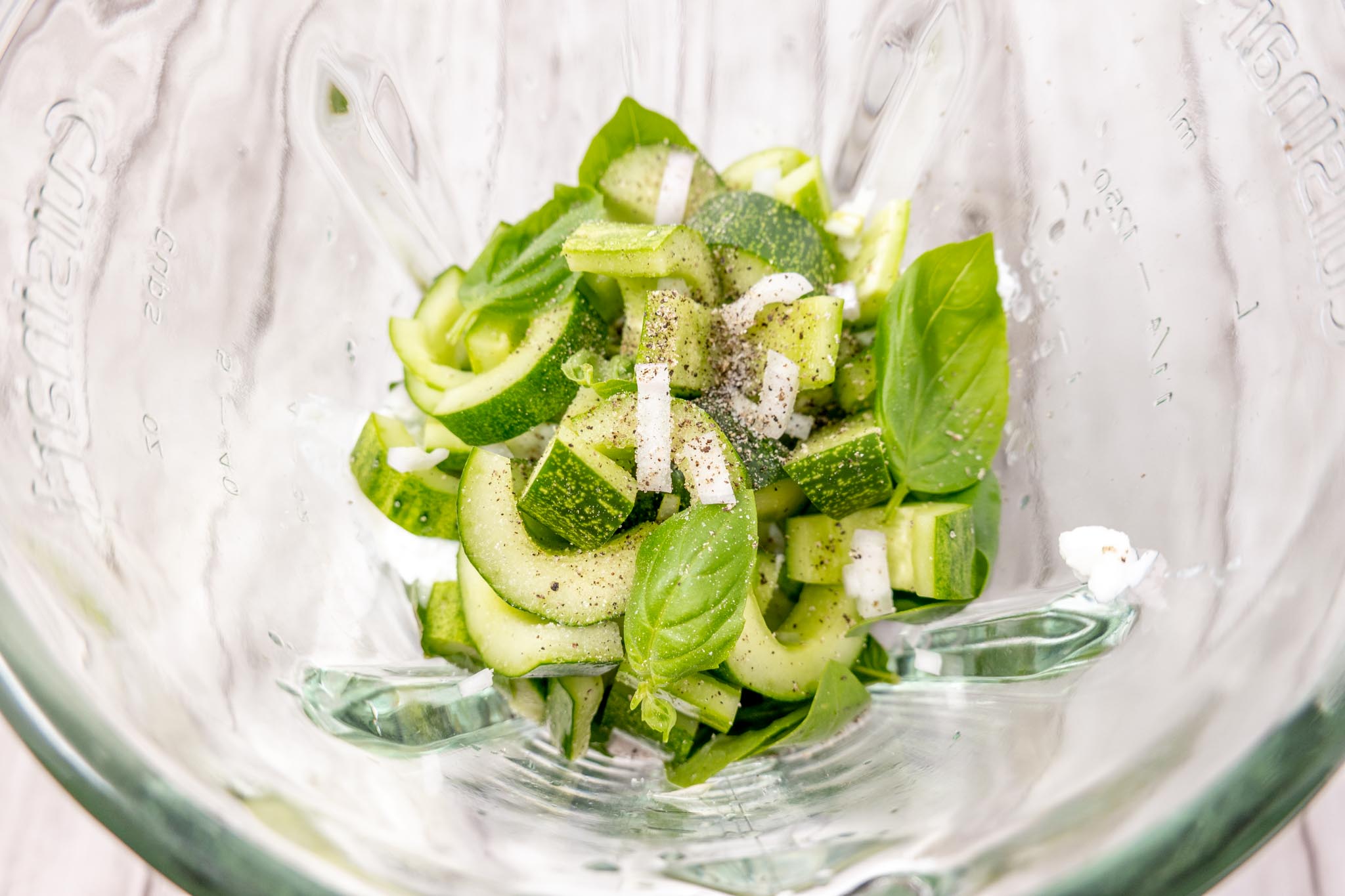 Chopped vegetables and herbs in a blender