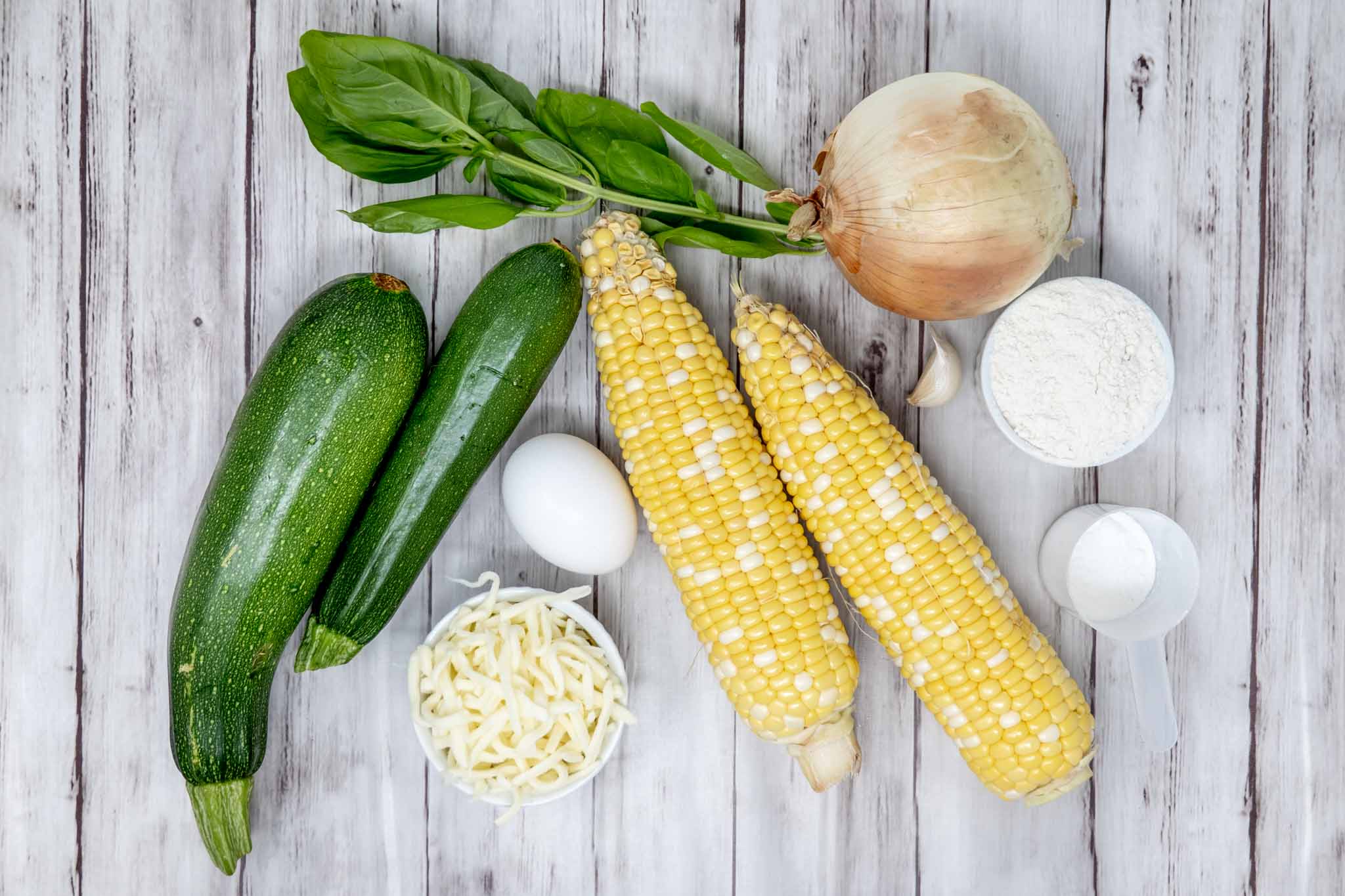 Zucchini, corn, onion, basil, grated cheese, egg, and flour