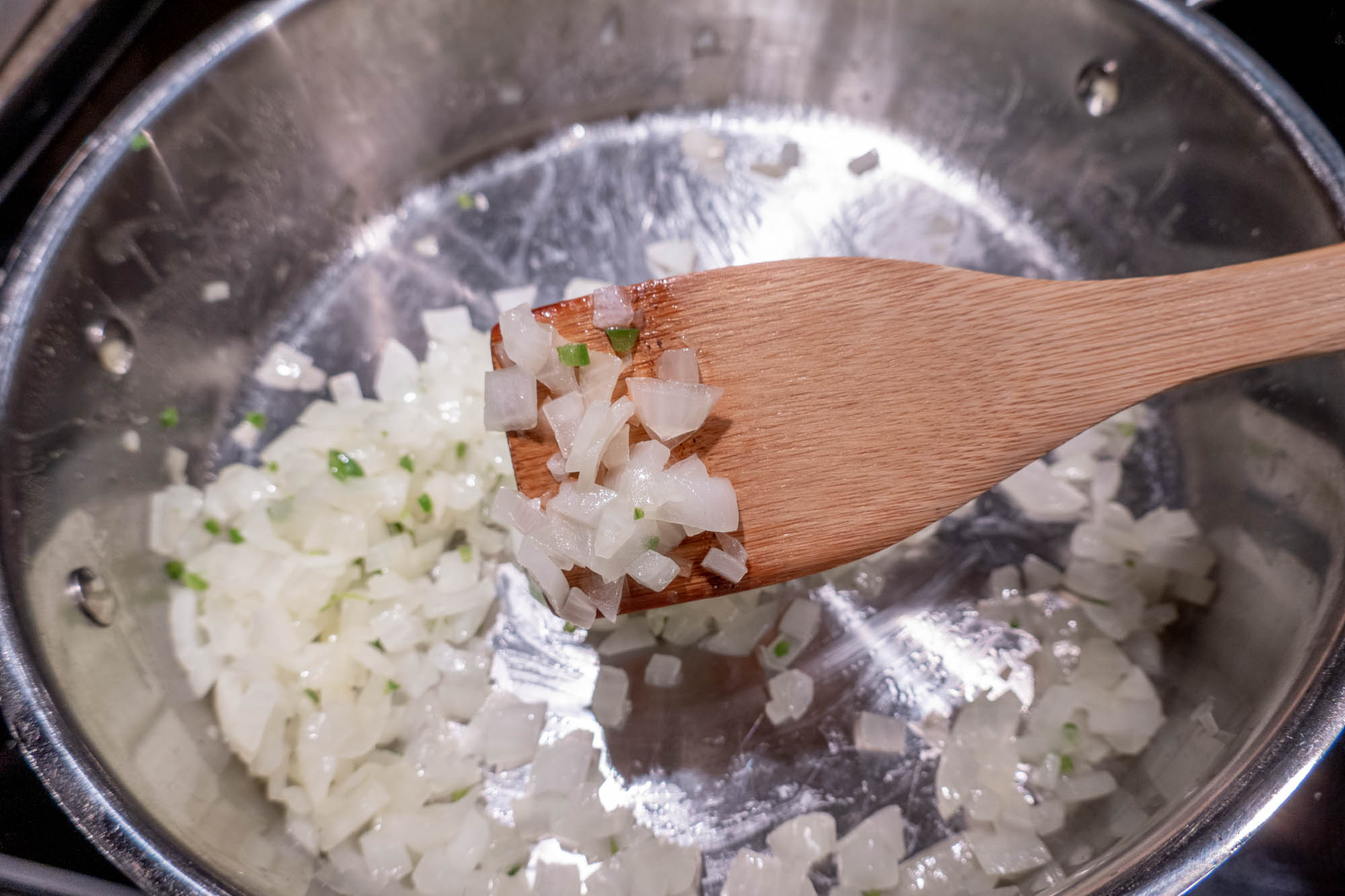 Translucent sauteed onion on a wooden spatula